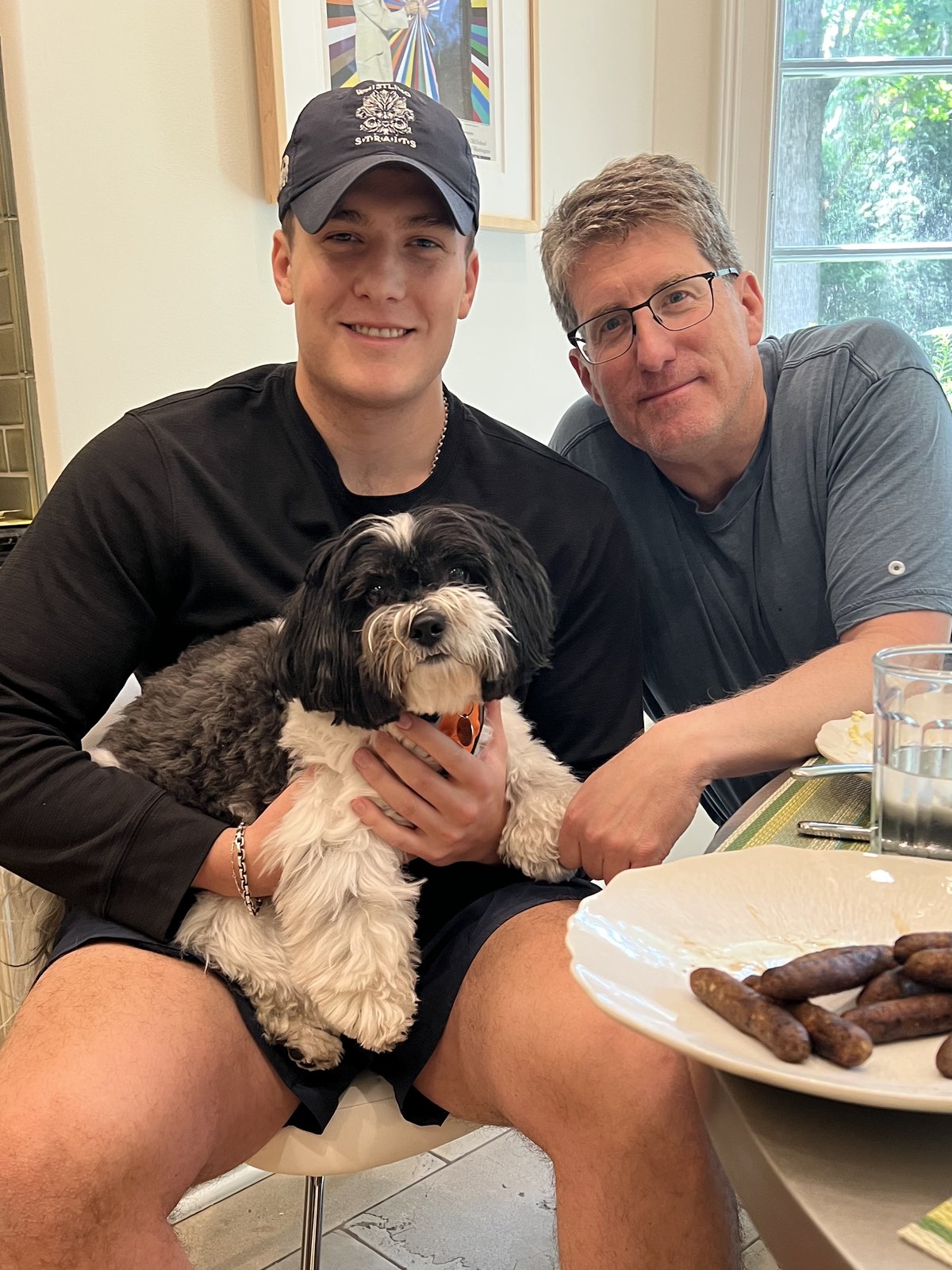Tommy holding a small black and white dog
